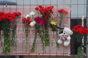 This photograph taken on March 23, 2024 shows flowers and a Teddy bear doll placed at a makeshift memorial in front of the Crocus City Hall in Krasnogorsk, outside Moscow, a day after a gun attack. Gunmen who opened fire at a Moscow concert hall killed more than 60 people and wounded over 100 while sparking an inferno, authorities said on March 23, 2024, with the Islamic State group claiming responsibility. (Photo by STRINGER / AFP)