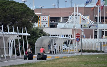 Passeggeri all'esterno dello scalo, in attesa dell'imbarco dopo il cessato allarme bomba all'aeroporto Marco Polo di Venezia, 22 giugno 2014. ANSA/ ANDREA MEROLA