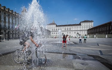 In cerca  di refrigerio nelle fontane di piazza Castello contro le alte temperature e caldo torrido per un'estate torinese. Torino 11 luglio 2023 ANSA/TINO ROMANO