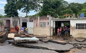 Residents try to recover their belongings from their flooded houses after a river swelled due to heavy rains following the passage of Hurricane Beryl on the road from Cumana to Cumanacoa, Sucre State, Venezuela, on July 2, 2024. Hurricane Beryl churned towards Jamaica Tuesday after killing at least five people and causing widespread destruction across the southeastern Caribbean, threatening deadly winds and storm surge as it approached. (Photo by Victor GONZALEZ / AFP) (Photo by VICTOR GONZALEZ/AFP via Getty Images)