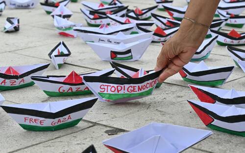 A flotilla of paper boats reading "Stop Genocide" "Free Gaza" are laid on the ground during a demonstration in support of Gaza and Palestinian people at Venice Lido during the 82nd Venice International Film Festival, on August 30, 2025. (Photo by Stefano RELLANDINI / AFP)