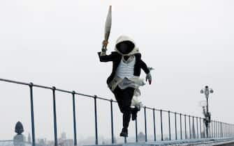 PARIS, FRANCE - JULY 26: A torchbearer runs atop the Musee d'Orsay during the Opening Ceremony of the Olympic Games Paris 2024 on July 26, 2024 in Paris, France. (Photo by Peter Cziborra - Pool/Getty Images)