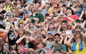 CARBONDALE, IL - AUGUST 21:  People watch the solar eclipse at Saluki Stadium on the campus of Southern Illinois University on August 21, 2017 in Carbondale, Illinois. Although much of it was covered by a cloud, with approximately 2 minutes 40 seconds of totality the area in Southern Illinois experienced the longest duration of totality during the eclipse. Millions of people are expected to watch as the eclipse cuts a path of totality 70 miles wide across the United States from Oregon to South Carolina on August 21.  (Photo by Scott Olson/Getty Images)