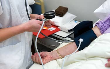 A nurse is measuring the blood pressure from a patient in a hospital