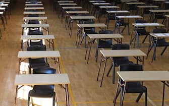 various views of an exam examination room or hall set up ready for students to sit test. multiple desks tables and chairs. Education, school, student