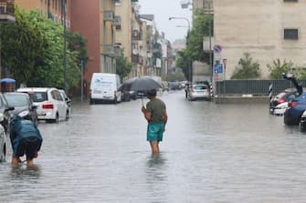 I residenti per strada dopo le fuoriuscite d'acqua causate da intense piogge nel quartiere di Ponte Lambro, alla porte di Milano, 15 maggio 2024. ANSA/PAOLO SALMOIRAGO