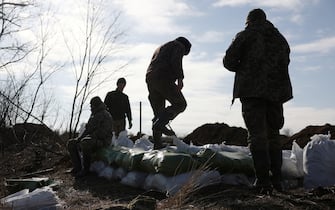 Ukrainian servicemen pile up earthbags to build a fortification not far from town of Avdiivka in the Donetsk region, amid the Russian invasion of Ukraine, on February 17, 2024. (Photo by Anatolii STEPANOV / AFP)