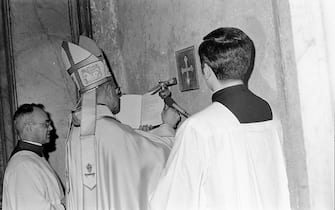 Papa Paolo VI (C), con monsignor Virgilio No?? (S-1), inaugura l'Anno Santo entrando dalla Porta Santa della Basilica di San Pietro, 24 dicembre 1974. ANSA
