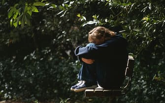 Un adolescente da solo su una panchina