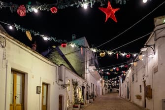 Christmas decorations and Christmas lights among the trulli of Alberobello, December 14, 2021.
Alberobello, the village of trulli, every year during the Christmas period attracts various onlookers from all over Italy and abroad. This year is even more fairytale at Christmas, with a monumental twenty meter tree, a kilometer of garlands, 500 colored balls and 1500 light bulbs that illuminate the entire town center (Photo by Davide Pischettola/NurPhoto via Getty Images)