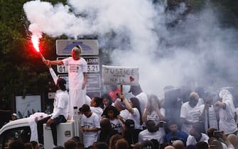 epa10717428 Nahel's mother (2-L top), wearing a 'Justice for Nahel' T-shirt, holds a flare as she attends a march in the memory of her 17-year-old son who was killed by French Police in Nanterre, near Paris, France, 29 June 2023. Violence broke out after the police fatally shot a 17-year-old during a traffic stop in Nanterre on 27 June. According to the French interior minister, 31 people were arrested with 2,000 officers being deployed to prevent further violence.  EPA/YOAN VALAT