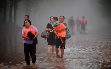 This photo taken on August 1, 2023 shows people evacuating from a flooded area after heavy rains in Zhuozhou, Baoding city, in China's northern Hebei province. (Photo by CNS / AFP) / China OUT (Photo by -/CNS/AFP via Getty Images)