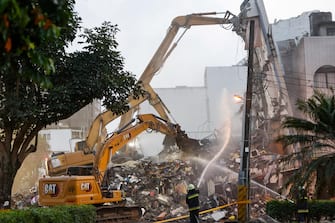 epa11257855 Firefighters spray water as excavators demolish the wreckage of a collapsed residential building following the 03 April magnitude 7.4 earthquake in Hualien, Taiwan, 04 April 2024. According to data released by Taiwan's National Fire Agency, the earthquake has taken at least nine lives and injured hundreds, making it the strongest earthquake in 25 years.  EPA/DANIEL CENG