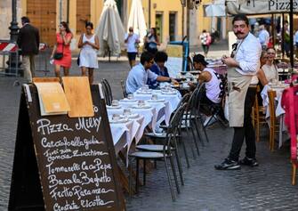 A waiter looks on at a restaurant's terrace in Rome's Jewish Quarter on September 15, 2020 during the COVID-19 infection, caused by the novel coronavirus. (Photo by Vincenzo PINTO / AFP) (Photo by VINCENZO PINTO/AFP via Getty Images)