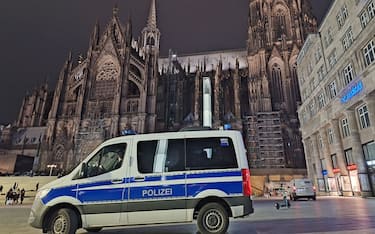 23 December 2023, North Rhine-Westphalia, Cologne: A police vehicle is parked in front of the cathedral. One day before Christmas, the police in Cologne are stepping up their protective measures due to possible plans for an attack. According to dpa, security authorities have received information about a possible plan by an Islamist group to attack Cologne Cathedral. Photo: Sascha Thelen/dpa (Photo by Sascha Thelen/picture alliance via Getty Images)