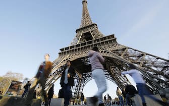 Tourists in front of the Eiffel tower in Paris, France, 15 November 2015.  At least 129 people were killed in a series of terrorist attacks in Paris on 13 November 2015. Photo: MALTE CHRISTIANS/dpa