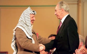 OSLO, NORWAY - MAY 18:  OSLO, NOR - MAY 18:  PLO Chariman Yasser Arafat (L) shakes hands with Israeli Foreign Minister Shimon Peres 18 May 1994 at a ceremony honoring Norway's role in the Israeli-PLO peace accord. Arafat said his recent call for a Moslem holy war was not a call for violence but a call to strive for complete Middle East peace.  (Photo credit should read SCANFOTO/AFP via Getty Images)