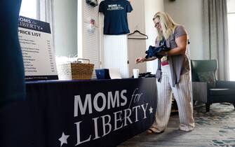 TAMPA, FL - JULY 15: Jara Jeffries of Iowa organizes Moms for Liberty apparel for sale in the hallway during the inaugural Moms For Liberty Summit at the Tampa Marriott Water Street on July 15, 2022 in Tampa, Florida. (Photo by Octavio Jones/Getty Images)