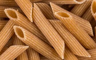 Wholemeal Pasta Penne as close-up shot for background