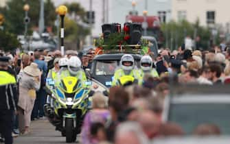 Fans of singer Sinead O'Connor line the streets for a "last goodbye" to the Irish singer as her funeral cortege passes through her former hometown of Bray, Co Wicklow, ahead of a private burial service. Picture date: Tuesday August 8, 2023.