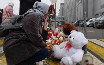 A woman mourns at a makeshift memorial in front of the Crocus City Hall, a day after a gun attack in Krasnogorsk, outside Moscow, on March 23, 2024. Camouflaged assailants opened fire at the packed Crocus City Hall in Moscow's northern suburb of Krasnogorsk on March 22, 2024, evening ahead of a concert by Soviet-era rock band Piknik in the deadliest attack in Russia for at least a decade. Russia on March 23, 2024, said it had arrested 11 people - including four gunmen - over the attack on a Moscow concert hall claimed by Islamic State, as the death toll rose to over 100 people. (Photo by Olga MALTSEVA / AFP) (Photo by OLGA MALTSEVA/AFP via Getty Images)