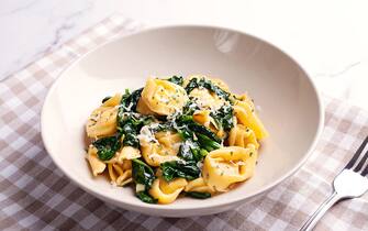 Front view of cheese tortellini with spinach on marble surface