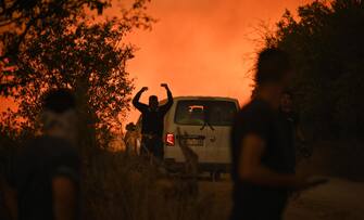 epa10812673 Volunteers operate to put out a wildfire in Avantas village, near the city of Alexandroupolis, Thrace, northern Greece, 21 August 2023. The wildfire that broke out early on 19 August in a forest in the Melia area of Alexandroupolis has spread rapidly due to the strong winds blowing in the area and is raging uncontrolled. The major wildfire in Alexandroupolis continues with unabated intensity for the third consecutive day. According to the Fire Department, the fire is difficult to be contained due to the strong winds in the area.  EPA/DIMITRIS ALEXOUDIS