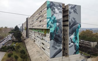 ROME, ITALY - 2023/02/16: (EDITORS NOTE: Image taken with a drone)
A 40-metre-long mural created by the Dutch street artist JDL (alter ego of the artist Judith de Leeuw) on a wall of the Corviale, a 958-metre-long public housing building (also called " the great serpent" due to its shape) in Rome. The subject draws inspiration from the myth of Icarus, a metaphor for a society intent on following a path that pays little attention to the precarious fate of the climate and the environment, leading it to self-destruction. (Photo by Stefano Costantino/SOPA Images/LightRocket via Getty Images)