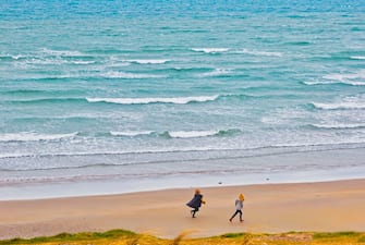 Two figures running on Inchydoney beach, Clonakilty, County Cork, West Cork, Republic of Ireland. Eire. (Photo by: Ken Welsh/Education Images/Universal Images Group via Getty Images)