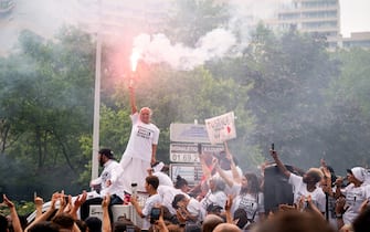 Mounia, mother of Nahel, 17, shot by a police officer, holds a flare during a demonstration in the Nanterre suburb of Paris, France, on Thursday, June 29, 2023. French authorities charged a police officer with murder in the shooting of a teenager earlier this week as the country braced for another night of violent clashes over the killing. Photographer: Benjamin Girette/Bloomberg