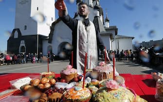 epa06652260 A Russian Orthodox priest sprinkles Holy water as he blesses Easter food and believers prior to the Orthodox Easter holiday celebration at the Church of St. Apostle Peter in St. Petersburg, Russia, 07 April 2018. Easter is the main religious celebration for Russian Orthodox Christians and will be celebrated this year on 08 April  according to the Julian calendar.  EPA/ANATOLY MALTSEV