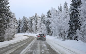 LAPLAND, FINLAND - NOVEMBER 23: A car passes by a road with snow view near the facilities around Rovaniemi in Lapland, Finland on November 23, 2023. Snowfall and cold weather are effective in the city of Rovaniemi, Lapland, which is among the important routes of tourists who want to see the 'Northern Lights', a natural phenomenon that takes place at certain times of the year. (Photo by smail Duru/Anadolu via Getty Images)