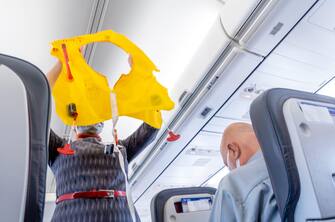 A flight attendant demonstrating life vest to passengers in a Boeing 737 narrowboby airplane operated by AnadoluJet, Turkish Airlines