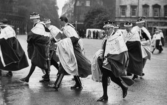 A group of peers hurrying from Westminster Abbey through the rain after the coronation ceremony of Queen Elizabeth II.   (Photo by Fox Photos/Getty Images)