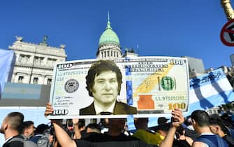 BUENOS AIRES, ARGENTINA - DECEMBER 10: A supporter holds a giant dollar bill with the face President elect Javier Milei as people start gathering outside National Congress ahead of during his Inauguration Ceremony on December 10, 2023 in Buenos Aires, Argentina. (Photo by Marcelo Endelli/Getty Images)