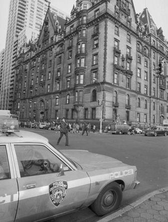 (Original Caption) Police direct traffic outside the Dakota, an apartment house, December 9th, the morning after former Beatle John Lennon was shot to death in front of the building. Police say Lennon was shot by a deranged man who had been stalking him for days.