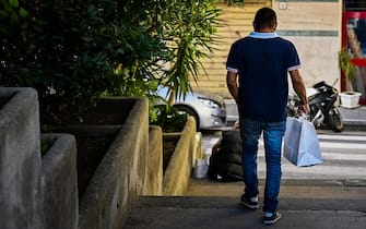 A man leaves after collecting a bag of food from Mario Conte's San Francesco soup kitchen, which is helped by the Catholic Caritas charity, on September 20, 2022 in Salerno. - Mario Conte fears the 140 hot meals his Salerno soup kitchen dishes out daily will not be anywhere near enough, should Italy's poverty relief scheme be scrapped after Sunday's elections. (Photo by Alberto PIZZOLI / AFP) (Photo by ALBERTO PIZZOLI/AFP via Getty Images)