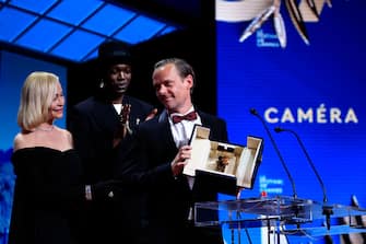 A member of the distribution delivers a speech after he was awarded with the Camera d'Or for the film "Armand" next to French actress, director, producer and President of the Camera d'Or jury Emmanuelle Beart and Congolese and Belgian director, songwriter, artistic director and President of the Camera d'Or jury Baloji during the Closing Ceremony at the 77th edition of the Cannes Film Festival in Cannes, southern France, on May 25, 2024. (Photo by Valery HACHE / AFP) (Photo by VALERY HACHE/AFP via Getty Images)