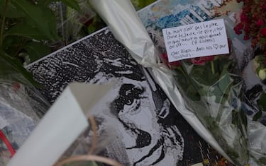 This photograph shows a portrait of late French actor Alain Delon amid flowers left by fans at the entrance gate of Delon's property La Brulerie in Douchy, central France, on August 23, 2024. Cinema legend Alain Delon, who died at 88, will be buried on August 24, 2024, a Catholic priest who is to officiate at the service told AFP, after Delon died at the age of 88, his three children told AFP in a statement on August 18, 2024, following a battle with ill health. (Photo by GUILLAUME SOUVANT / AFP)