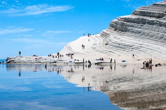 SCALA DEI TURCHI, REALMONTE, SICILY, ITALY - 2016/06/06: Sun-bakers at Scala dei Turchi, or Stairs of the Turks, at Realmonte, southern Sicily, Italy. The Scala is formed by marl, a sedimentary rock with a characteristic white color and is a popular tourist attraction and place to sun bake. (Photo by Leisa Tyler/LightRocket via Getty Images)