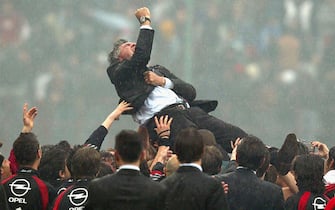MILAN, ITALY - MAY 2:  Milan's manager Carlo Ancelotti is lifted above his players heads during celebrations of Milan's victory following the Serie A match between Milan and Roma played at the San Siro stadium on May 2, 2004 in Milan, Italy.  (Photo by Newpress/Getty Images)