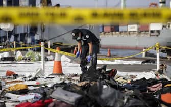 epa07136521 An Indonesian forensic police officer takes samples from recovered belongings of the passangers of the crashed Lion Air flight JT610 at Tanjung Priok port in Jakarta, Indonesia, 02 November 2018. Lion Air flight JT-610 lost contact with air traffic controllers soon after takeoff then crashed into the sea on 29 October. The flight was en route to Pangkal Pinang, and reportedly had 189 people onboard.  EPA/MAST IRHAM