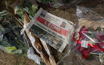 This photograph shows front page of L'Echo newspaper with a headline which reads in French "How to say goodbye" amid flowers left by fans of the late French actor Alain Delon at the entrance gate of Delon's property La Brulerie in Douchy, central France, on August 23, 2024, on the eve of his funerals. French film legend Alain Delon has died at the age of 88, his three children told AFP in a statement on August 18, 2024, following a battle with ill health. (Photo by GUILLAUME SOUVANT / AFP)