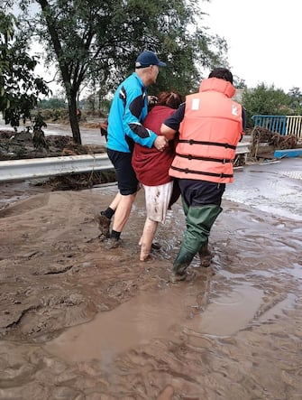 epa11603985 A handout photo made available by the Romanian General Inspectorate for Emergency Situations (IGSU) shows a woman being helped by rescuers to get out of a flooded street to a safer place, in the flood-affected village of Pechea, near Galati city, Romania, 14 September 2024. Four people have died in Galati County and about 5,000 homes have been damaged as a result of flooding caused by heavy rains brought by Cyclone Boris. Romanian authorities announced that operations in the affected areas are challenging due to floods blocking several roads. Hydrologists have issued a red flood code for the Siret (Galati county) and Prut rivers (Vaslui county).  EPA/ROMANIAN GENERAL INSPECTORATE FOR EMERGENCY SITUATIONS HANDOUT -- MANDATORY CREDIT -- BEST QUALITY AVAILABLE -- HANDOUT EDITORIAL USE ONLY/NO SALES