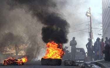 TOPSHOT - This screen grab taken from AFPTV shows tires on fire near the main prison of Port-au-Prince, Haiti, on March 3, 2024, after a breakout by several thousand inmates. At least a dozen people died as gang members attacked the main prison in Haiti's capital, triggering a breakout by several thousand inmates, an AFP reporter and an NGO said on March 3. "We counted many prisoners' bodies," said Pierre Esperance of the National Network for Defense of Human Rights, adding that only around 100 of the National Penitentiary's estimated 3,800 inmates were still inside the facility after the gang assault overnight on March 2. (Photo by Luckenson JEAN / AFPTV / AFP) (Photo by LUCKENSON JEAN/AFPTV/AFP via Getty Images)