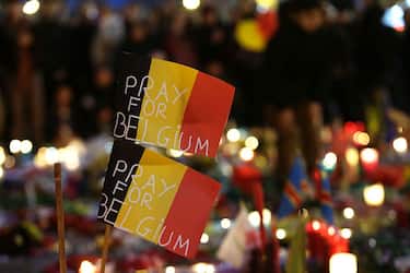 Belgian flags reading "Pray for Belgium" are pictured as people gather at a makeshift memorial on the Place de la Bourse (Beursplein) in Brussels on March 23, 2016, a day after a triple bomb attack, which responsibility was claimed by the Islamic State group, left 31 dead and hundreds injured in the Belgian capital. World leaders united in condemning the carnage in Brussels and vowed to combat terrorism, after Islamic State bombers killed 31 people in a strike at the symbolic heart of the EU. AFP PHOTO / KENZO TRIBOUILLARD / AFP / KENZO TRIBOUILLARD        (Photo credit should read KENZO TRIBOUILLARD/AFP via Getty Images)