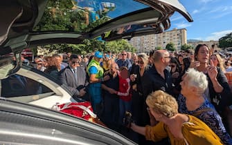 Folla di persone circonda la bara del calciatore Totò Schillaci al quartiere CEP di Palermo nel giorno del funerale, 20 settembre 2024 ANSA / Igor Petyx --- Crowd of people surround the coffin of footballer Totò Schillaci in the CEP district of Palermo on the day of the funeral, 20 september 2024 ANSA / Igor Petyx