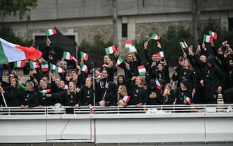 Athletes from Italy's delegation wave flags as they sail on a boat along the river Seine during the opening ceremony of the Paris 2024 Olympic Games in Paris on July 26, 2024. (Photo by Miguel MEDINA / AFP) (Photo by MIGUEL MEDINA/AFP via Getty Images)