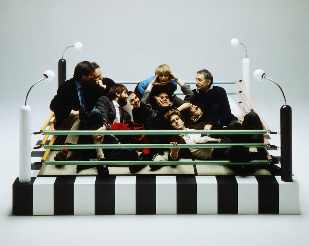 I membri fondatori del gruppo Memphis seduti sul letto Tawaraya (1981) progettato dall’architetto giapponese Masanori Umeda come area conversazione a forma di ring. Memphis srl/Foto Studio Azzurro