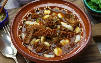 Menudo Rojo is a traditional mexican soup made with honeycomb tripe and hominy in broth with chile guajillo base.